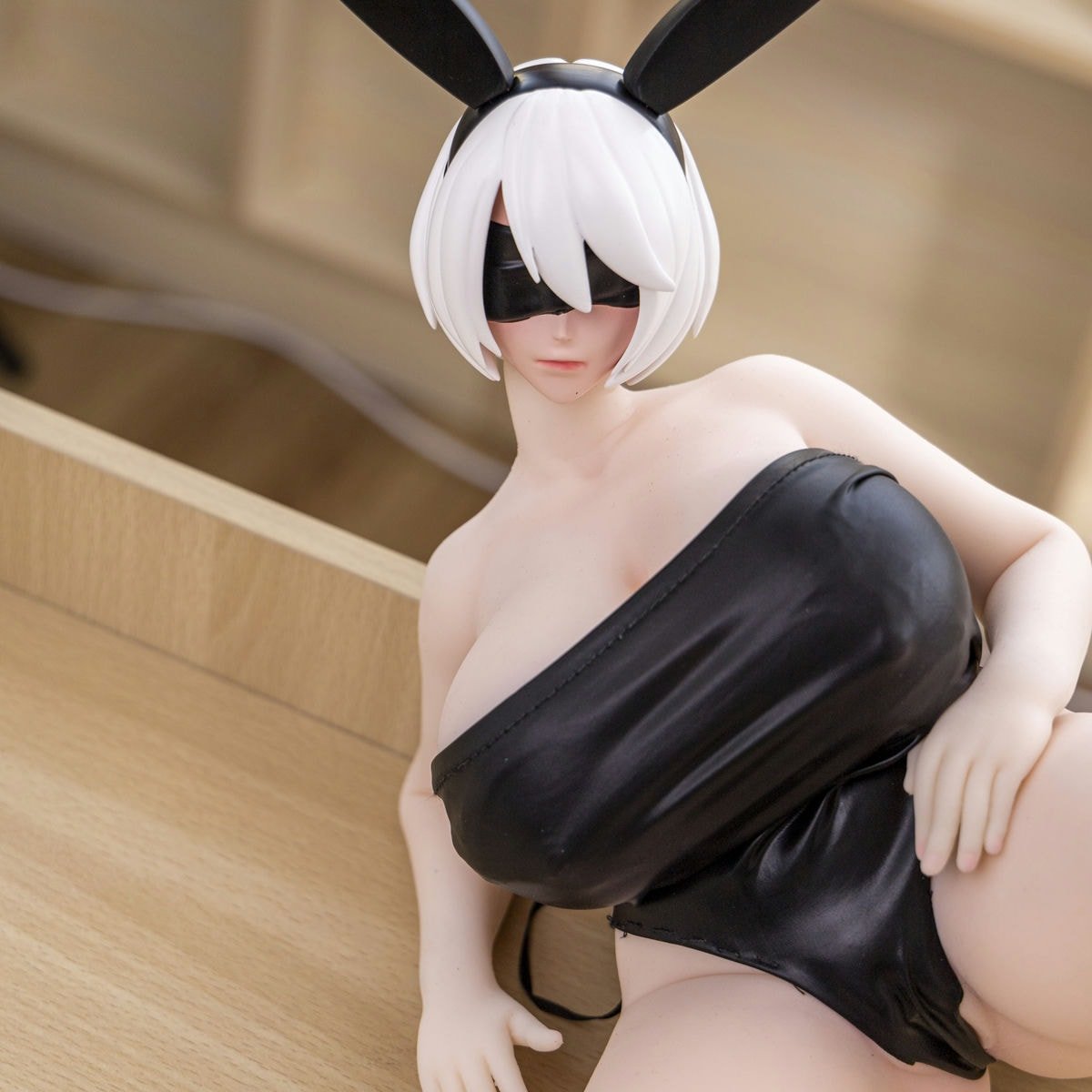 Chest close-up of the 2B mini anime doll in a black wrap top