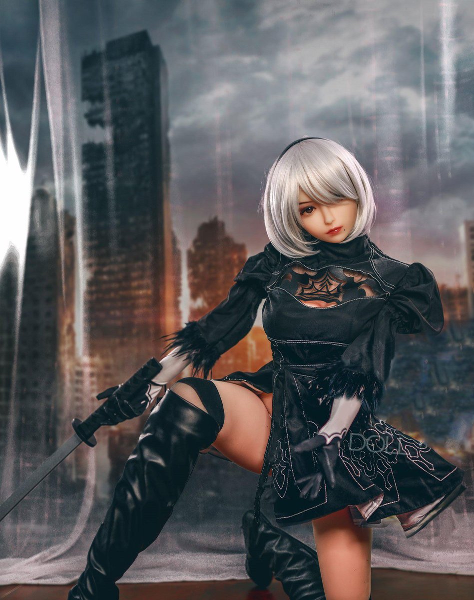 2B gaming sex doll seated with a prop sword, thigh boots and black dress