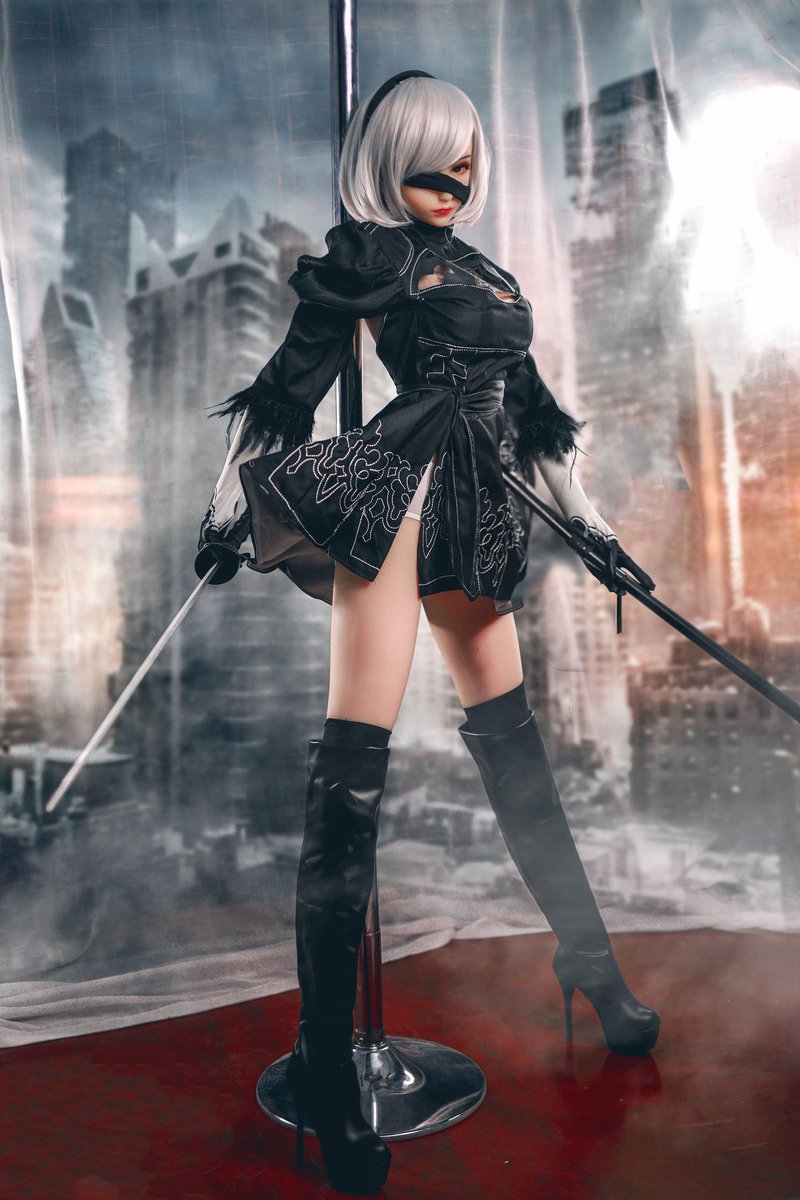 2B gaming sex doll standing with two prop swords in full costume