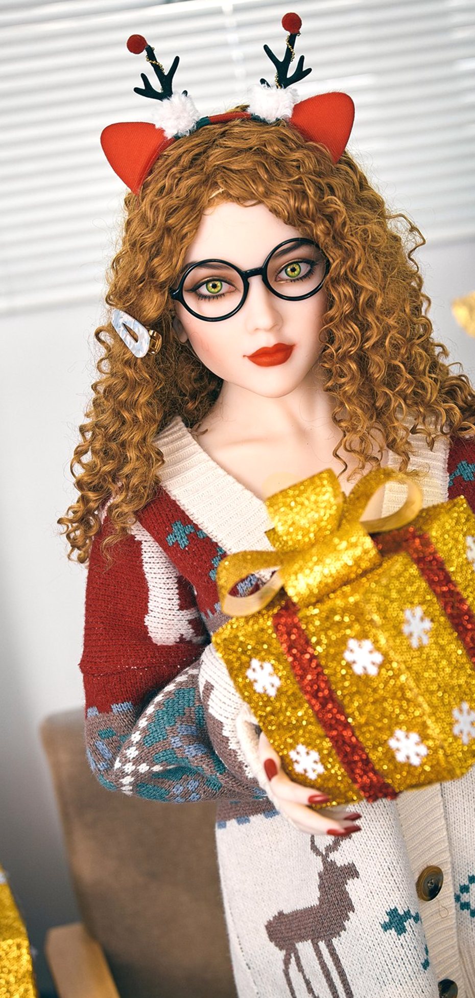 Daisy, a 150 cm sex doll in a reindeer cardigan holding a glitter gift box