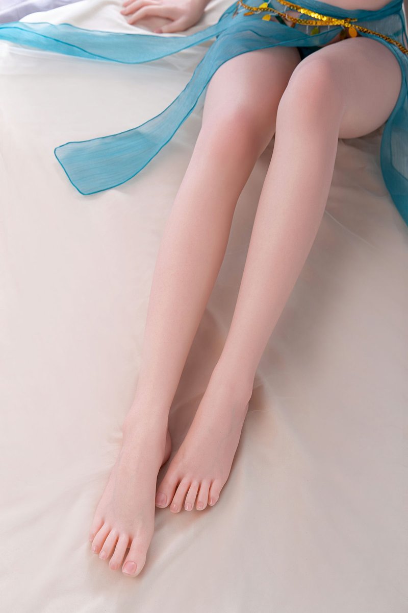 Lakenya, a 165 cm Asian TPE sex doll, lower legs and bare feet on a white sheet