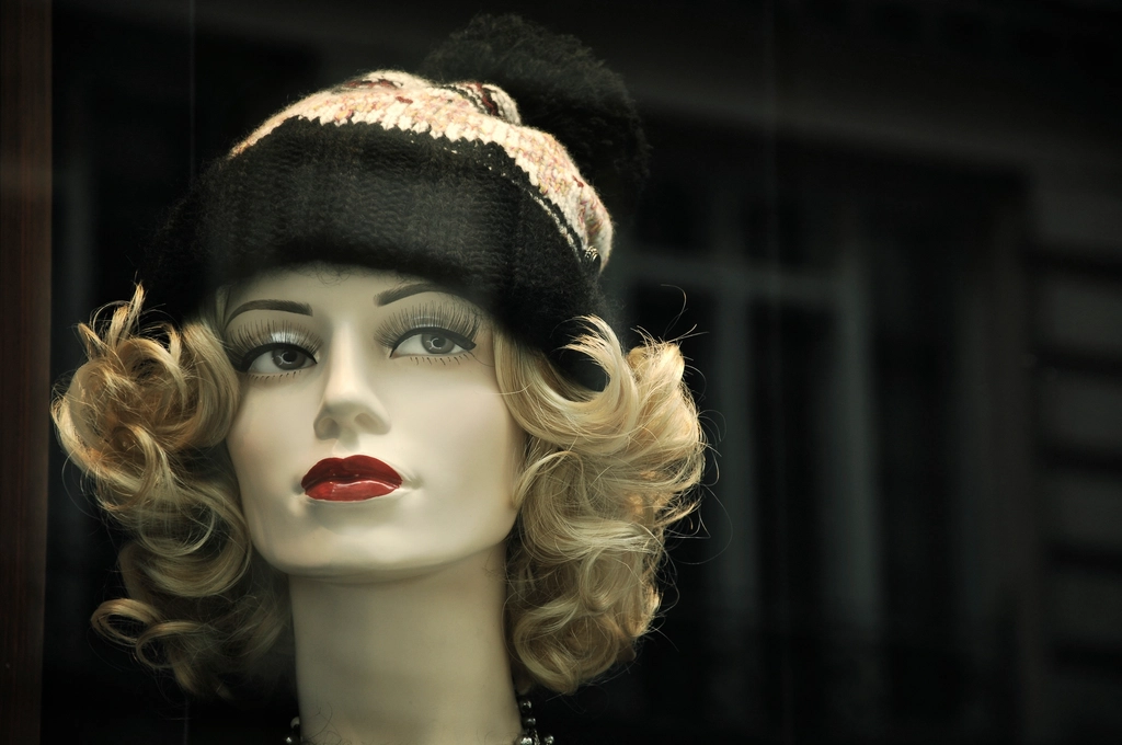 Mannequin display head wearing a blonde wig and a knitted hat