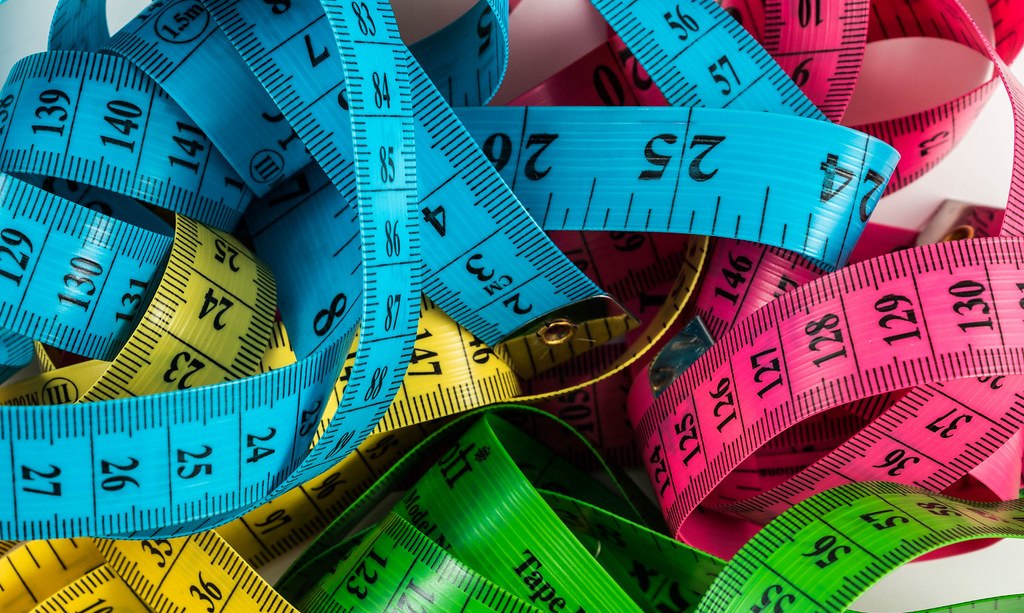 Colorful tailor measuring tapes coiled in a pile