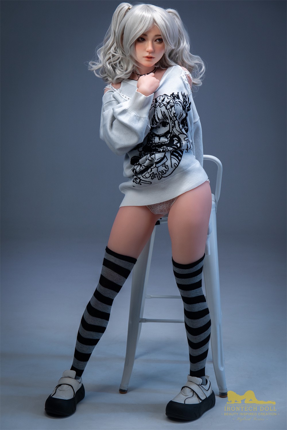 Olivia, a 154 cm hybrid sex doll standing front-on in a printed sweater
